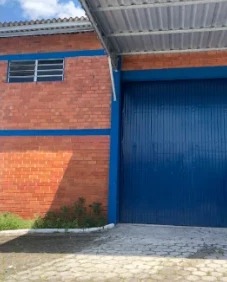 Fachada de galpão com portão azul, em 2019